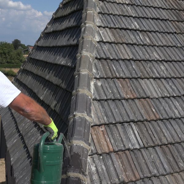 Hans bewatert het cement om onthechting te voorkomen.