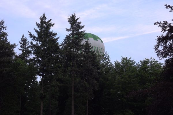 Een luchtballon scheert over het erf.