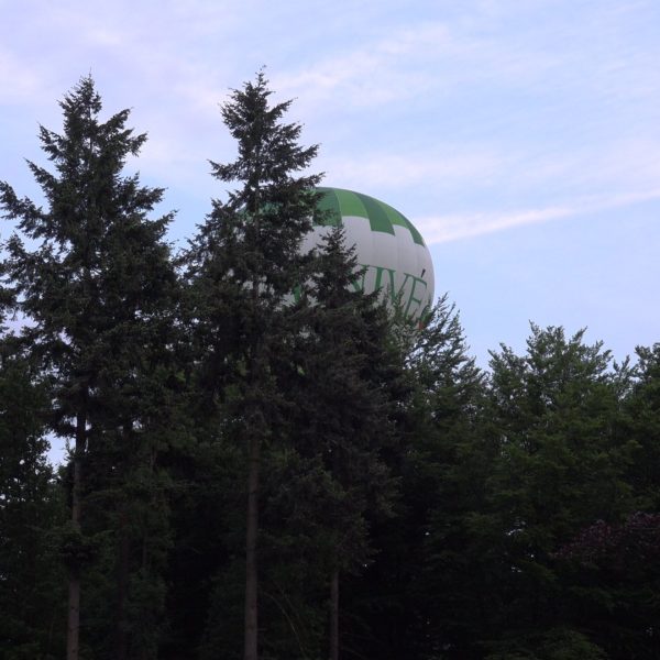 Een luchtballon scheert over het erf.