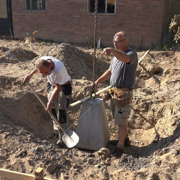 Hans en Sander plaatsen poeren voor de carport.