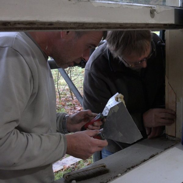 Peter en Erwin repareren een raamkozijn.